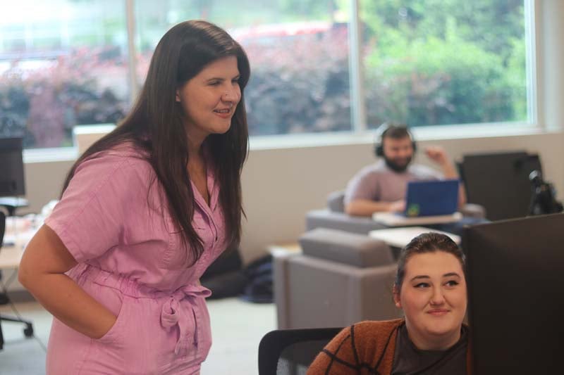 Two coworkers looking at a monitor