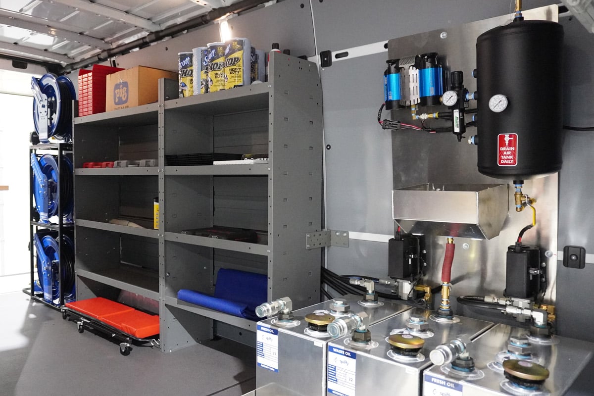 Inside a mobile service van with organized storage, oil tanks, and equipment for efficient vehicle maintenance.