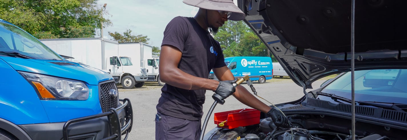 Spiffy technician performing a mobile oil change service on a fleet vehicle