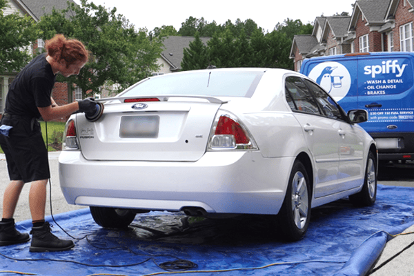 Spiffy Tech performs a hand wash on the back of a customer's car