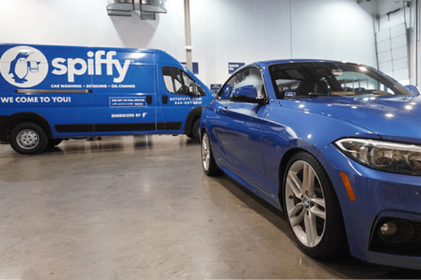Completed customer car shines in front of a spiffy van with its freshly applied ceramic coating.