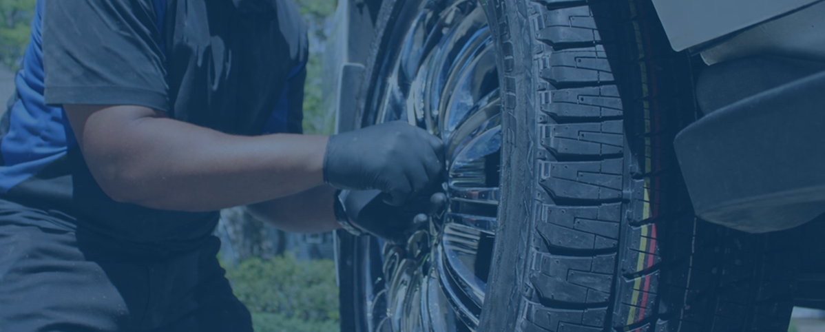 Spiffy technician servicing a vehicle wheel and tire during fleet onboarding.