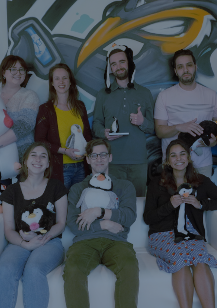 Spiffy workers taking a photo holding a penguin stuffed animal